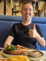 Jesper aan tafel in een Australische pub met een Sunday roast en friet